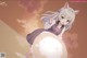 Anime girl with long white hair and green eyes holding a white ball.