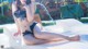 A woman in a bikini sitting on a water slide.