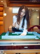 A woman playing a game of mahjong on a table.