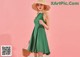 a woman in a green dress and straw hat