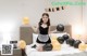 A woman sitting on a bed holding a bunch of balloons.