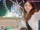 A woman taking a selfie in front of a ferris wheel.