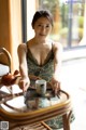 A woman sitting at a table with a cup of tea.