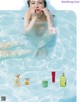 A woman in a swimming pool with a body care product.